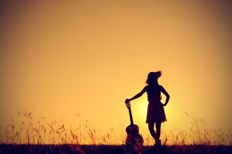 silhouette-of-woman-holding-guitar-in-sunset